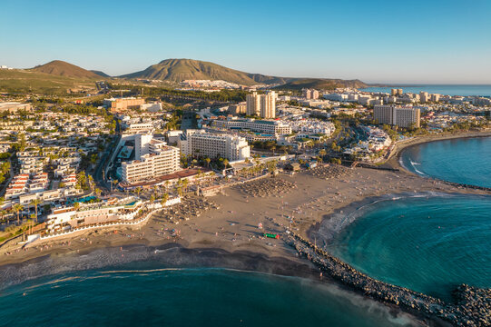 Strandpromenade mit Liegen und Palmen in Playa de las Américas, Teneriffa